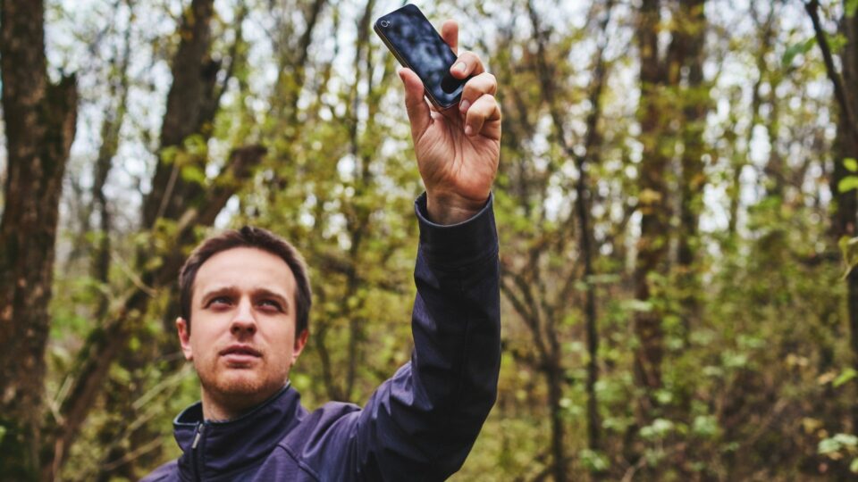 Man in forest looking for cell service